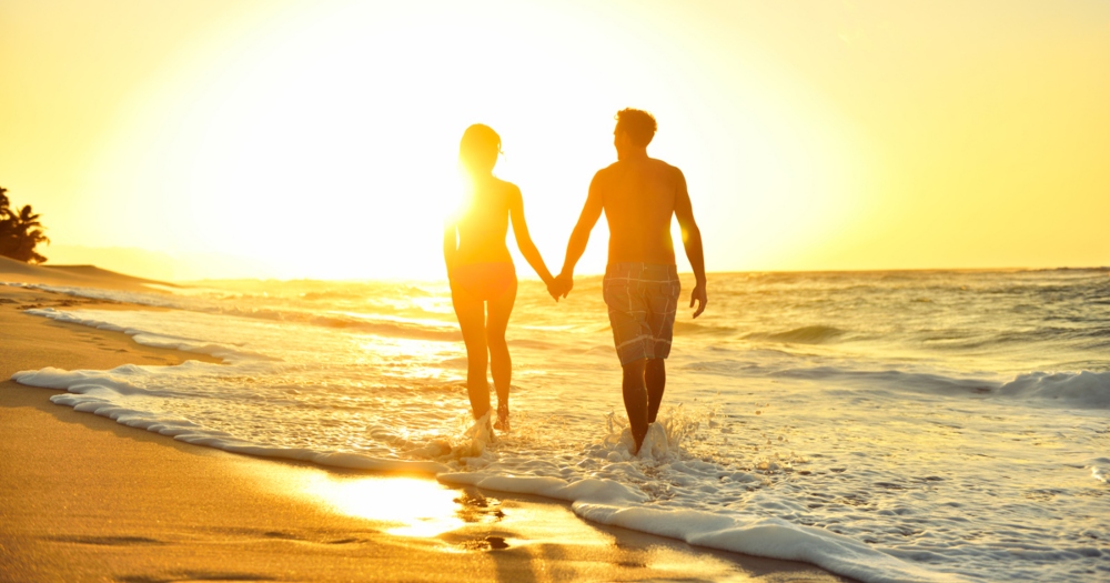 couple-walking-on-romantic-kauai-beach-at-sunset